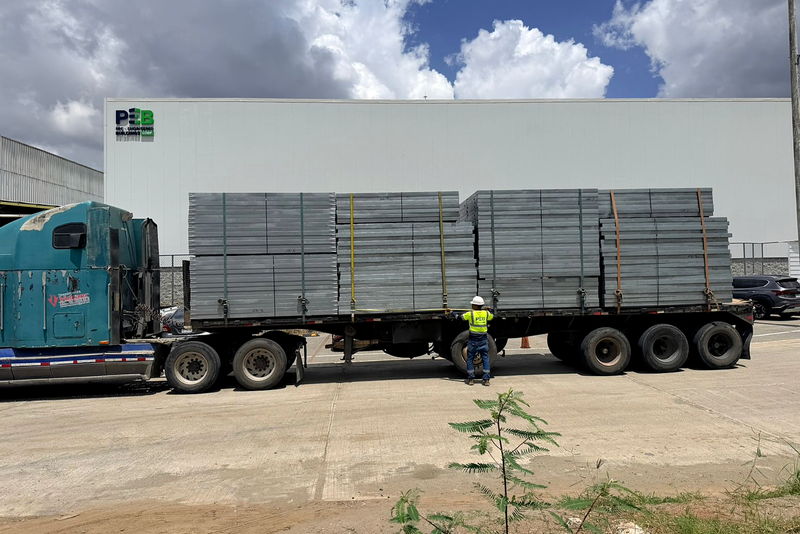 Camión cargado con paneles estructurales saliendo de la planta del grupo